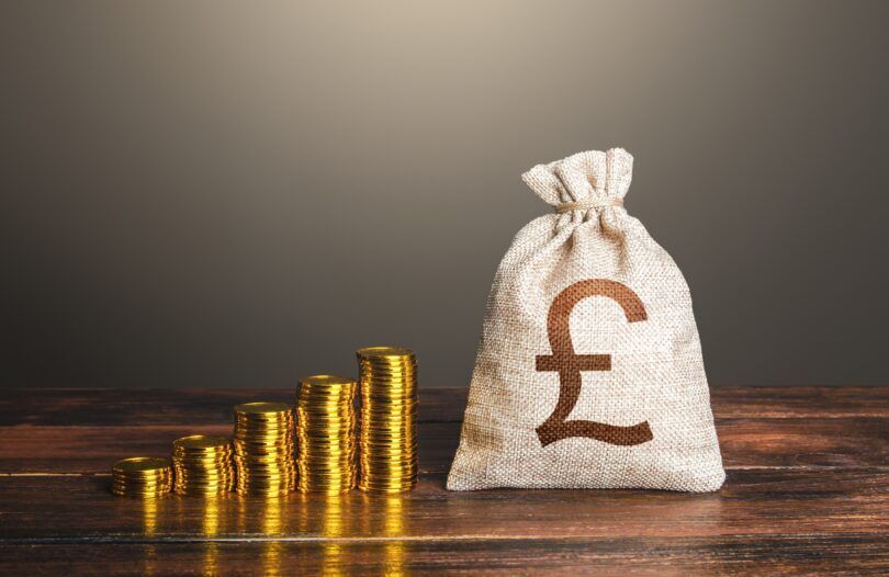 Rising UK inflation represented by stacked coins.