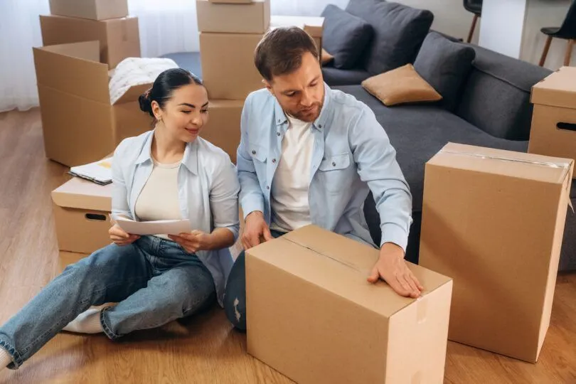 Smiling young couple inside their new UK home after securing a Nationwide 6x income mortgage.